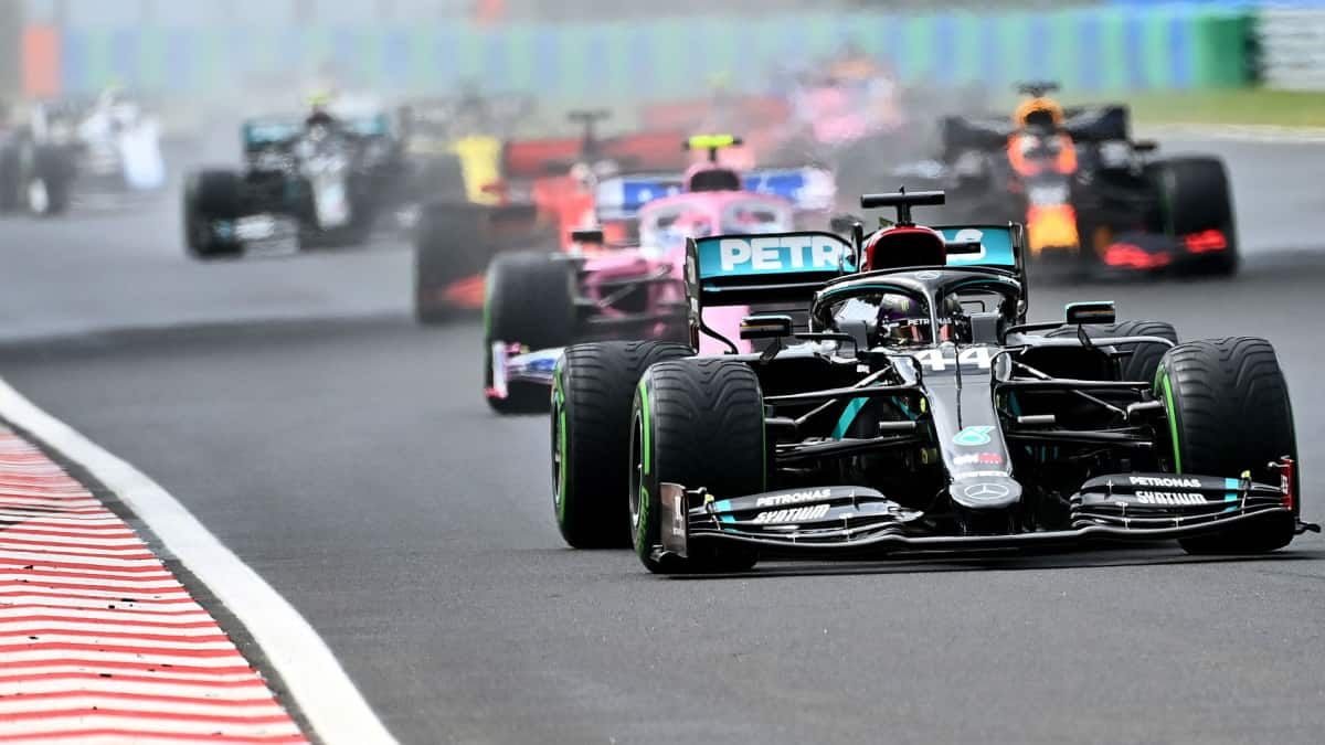Carros de Fórmula 1 disputando posição na pista durante uma corrida